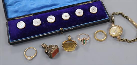 A 22ct wedding band, two other yellow metal rings, a ladys 9ct watch, two fobs and a dress stud set.